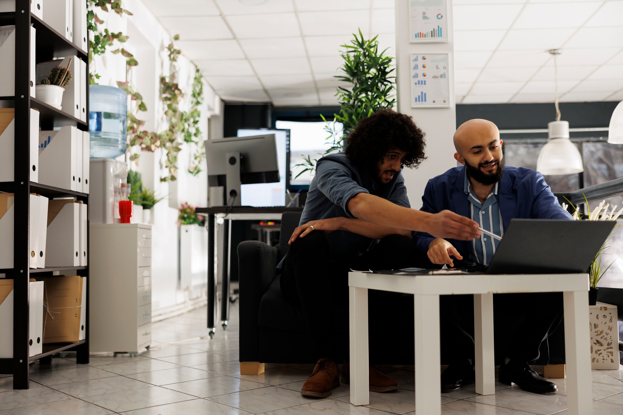 Two arab entrepreneurs reviewing financial analytics on laptop